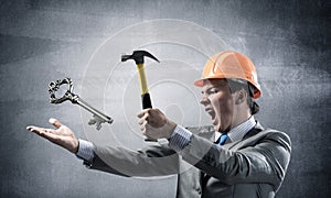 Businessman going to crash with hammer steel key
