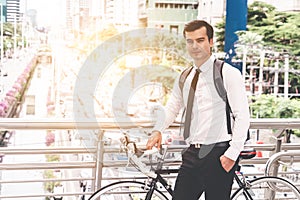 Businessman going to work by bike in a traffic jam city