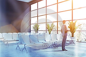 Businessman in gray airport waiting room