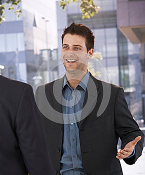 Businessman greeting colleague at office