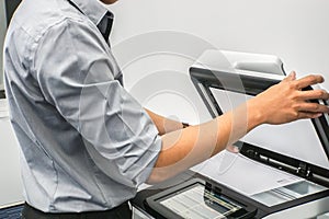 Businessman with grey shirt use printer to scan confidential documents in office