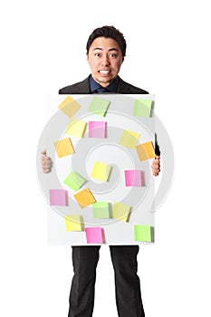 Businessman in grey suit with board full of notes