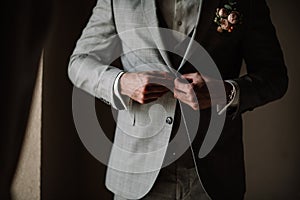 Businessman or groom in white shirt with minty tie fasten button of his blue tweed jacket