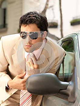 Businessman grooming on car mirror.