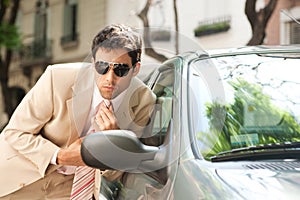 Businessman grooming on car mirror.