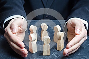 Businessman guards a circle of people with his hands. Team insurance. Preservation protection of company, ensuring safety of