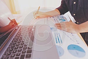 Businessman hand analyzing chart on paper investment charts with laptop. Accounting. Business concept