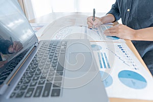 Businessman hand analyzing chart on paper investment charts with laptop. Accounting. Business concept