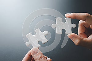 Businessman hand connecting jigsaw puzzle, Business solutions, target, success, goals and strategy concepts