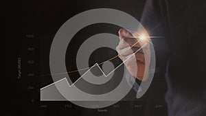 Businessman hand drawing chart graph stock of growth. Hand man uses pen to draw stock graph chart point of target success.