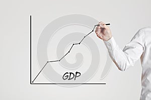 Businessman hand draws a rising line graph with the word GDP. Gross domestic product increase