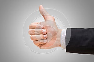 Businessman hand giving thumbs up on over gray background