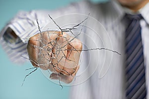 Businessman hand hitting the transparent glass with cracked