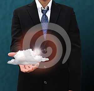 Businessman hand hold the cloud against blue sky with clouds