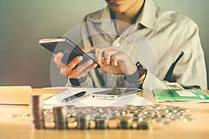 Businessman of hand holding a calculator on the table with a medal recognizing computation and Sunset light Business Background