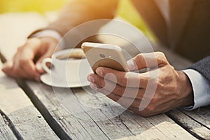 Businessman hand holding coffee and reading phone