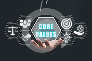 Businessman hand holding core values icon on virtual screen