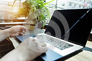 Businessman hand holding credit card using laptop computer typing keyboard
