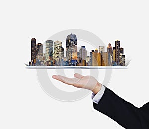 Businessman hand holding digital tablet with modern buildings hologram. Smart city, building technology and real estate business