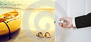 Businessman hand holding door knob, opening to the beach with yellow kayak and flip flop, vintage tone, business summer vacation