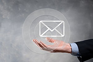 Businessman hand holding e-mail icon, Contact us by newsletter email and protect your personal information from spam mail.