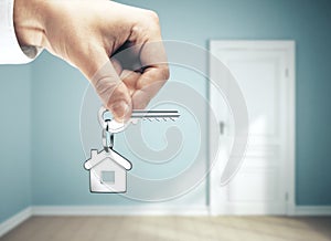 Businessman hand holding key to house