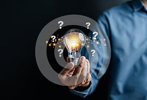 Businessman hand holding light bulb with brain into smart, creative, idea thinking to innovation brainstorm and imagination