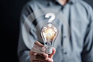 Businessman hand holding light bulb with brain into smart, creative, idea thinking to innovation brainstorm and imagination