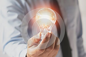 businessman hand holding light bulb. idea concept with innovation and inspiration