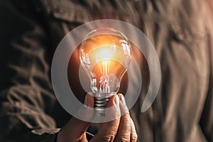 businessman hand holding lightbulb. idea Alternative energy concept saving electricity