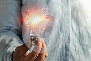 businessman hand holding lightbulb. idea Alternative energy concept saving electricity