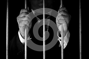 Businessman Hand Holding Metal Bars In Jail with dark environments