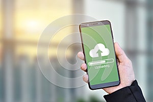 Businessman hand holding mobile smartphone with cloud upload