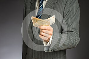 Businessman hand holding money, euro bills. Banknotes isolated gray background.