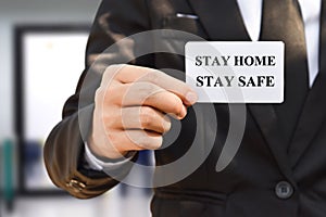 Businessman hand holding paper card with stay home