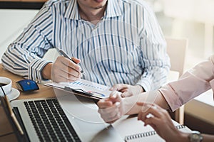 Businessman hand holding pen in meeting room