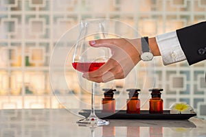 Businessman hand holding a red wine glass on table  inside bar & restaurant. Spa Treatments Concept