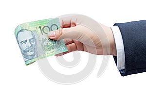 Businessman hand holding roll Australian dollars (AUD).