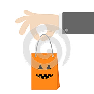 Businessman hand holding shopping paper bag handle. Pumpkin smile face emotion. Present inside. Special offer. Happy Halloween sig