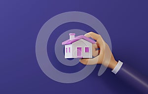 Businessman hand holding a small house with pink roof on a purple background