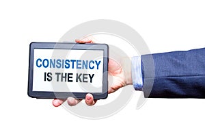 Businessman hand holding tablet with Consistency is The Key text