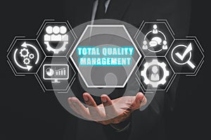 Businessman hand holding total quality management icon on virtual screen
