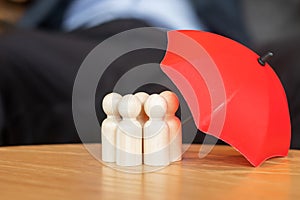 Businessman hand holding umbrella and cover man wooden from crowd of employees. People, Business, Human resource management, Life