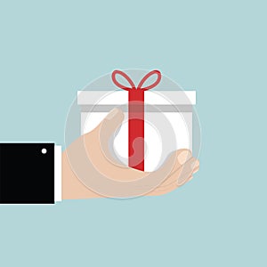 Businessman hand holding white gift box with red bow.