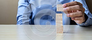 Businessman hand holding wooden cube with GOAL text on table background. success, strategy, solution and business concepts