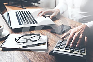 Businessman hand keyboard with calculator and stationary on table