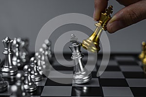 Businessman hand moving gold Chess King figure and Checkmate opponent during chessboard competition. Strategy, Success, management