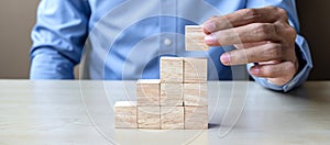 Businessman hand placing or pulling wooden block on the building. Business planning, Risk Management, Solution and strategy