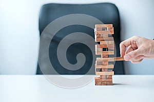 Businessman hand placing or pulling wooden block on the tower. Business planning, Risk Management, Solution and strategy Concepts