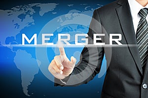 Businessman hand pointing to MERGER sign photo